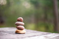 Stack of stones on a wooden surface with a blurred natural background